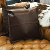 Brown leather pillow on tan tufted leather sofa with cowhide accent