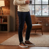 Man wearing brown leather sneakers and dark jeans in modern loft living room