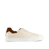 Men’s off-white leather sneaker with brown suede heel accent and white sole on white background
