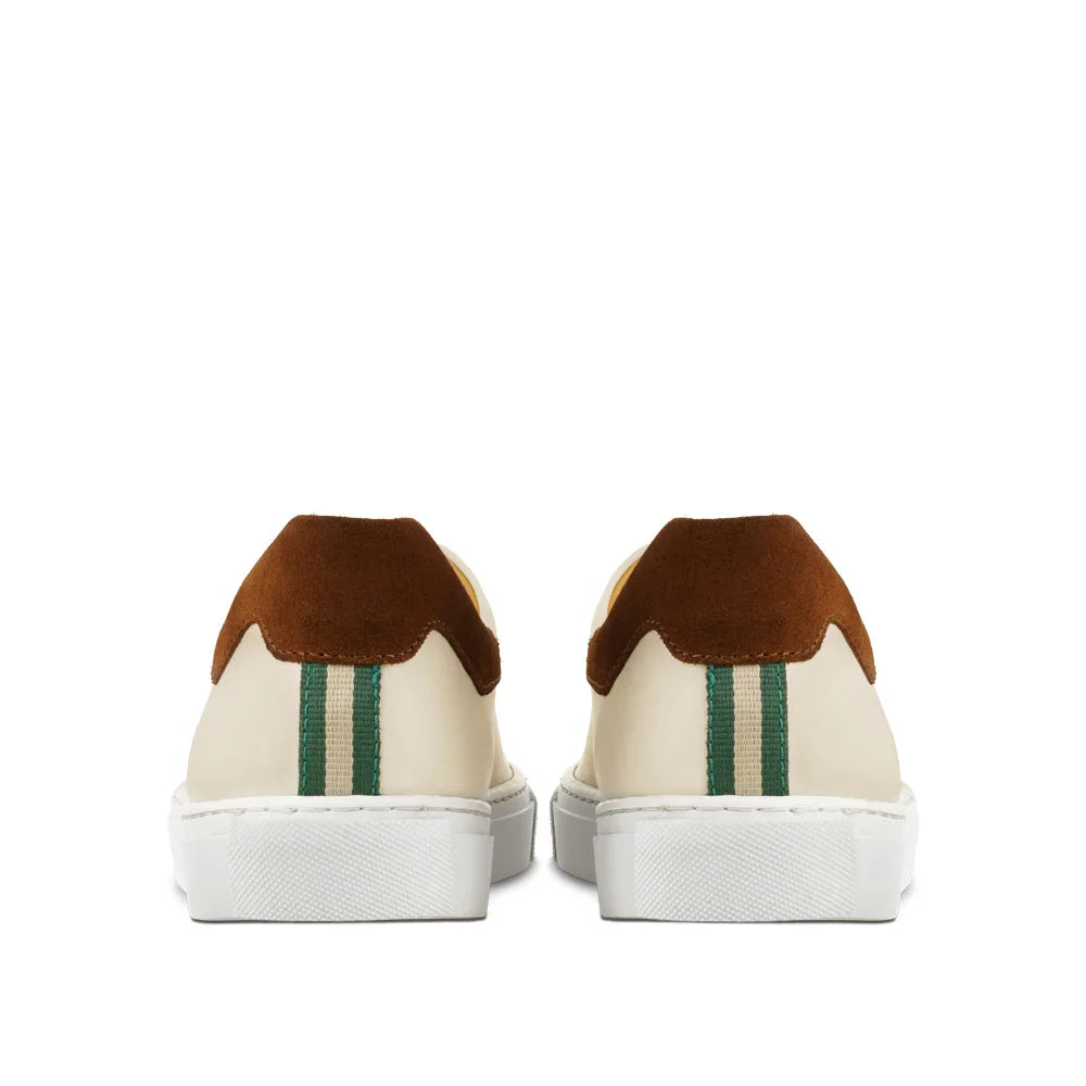 Rear view of cream sneakers with brown suede detail and green striped heel accent