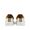 Rear view of cream sneakers with brown suede detail and green striped heel accent