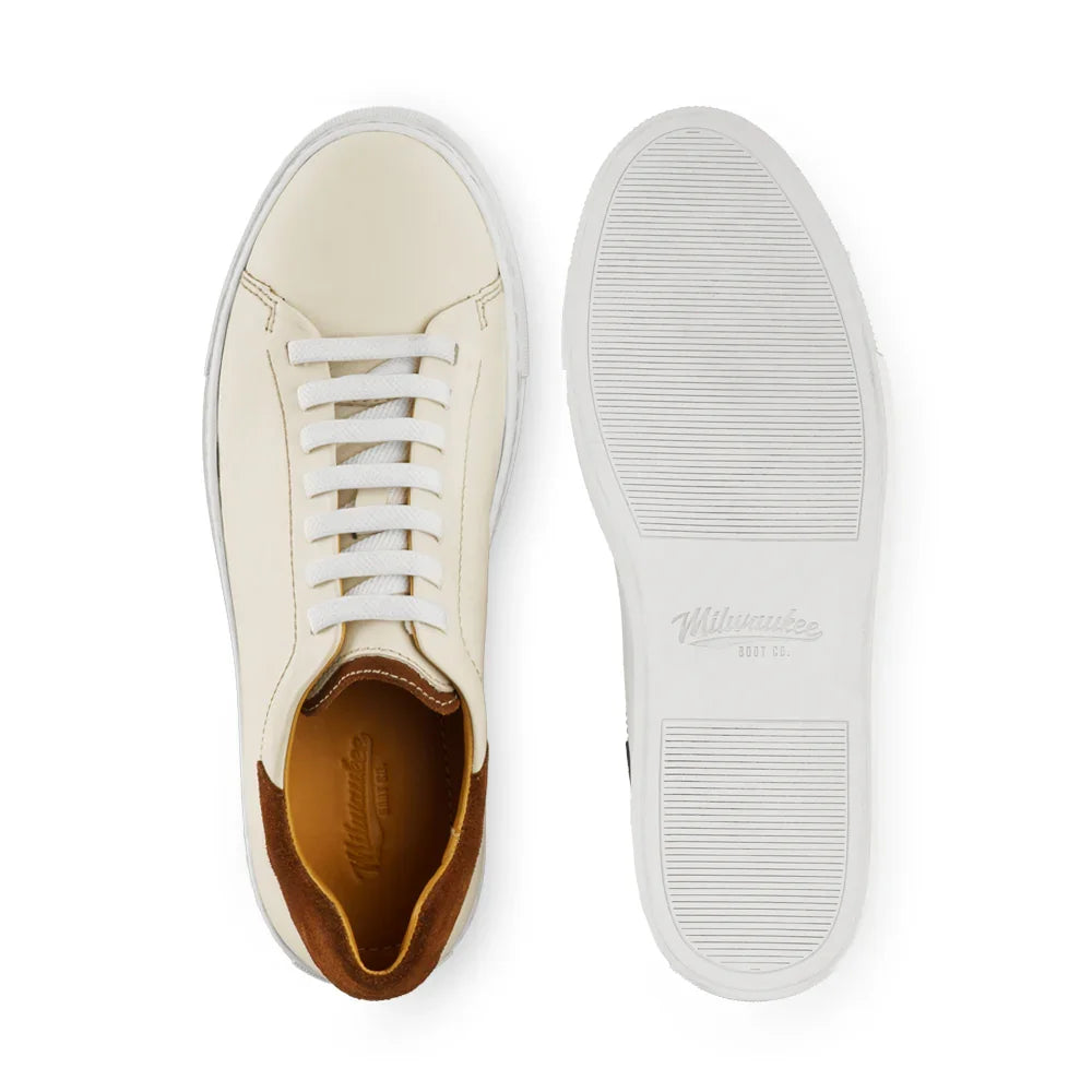Cream leather sneaker with brown suede heel and white rubber sole, top and bottom view