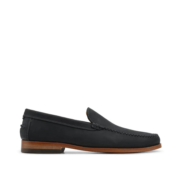 Black leather loafer with brown sole, classic slip-on dress shoe, side view on white