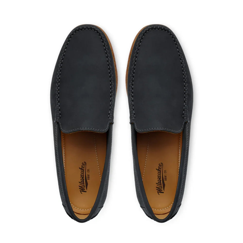 Pair of black leather loafers with tan interior, moc toe stitching, top view on white background