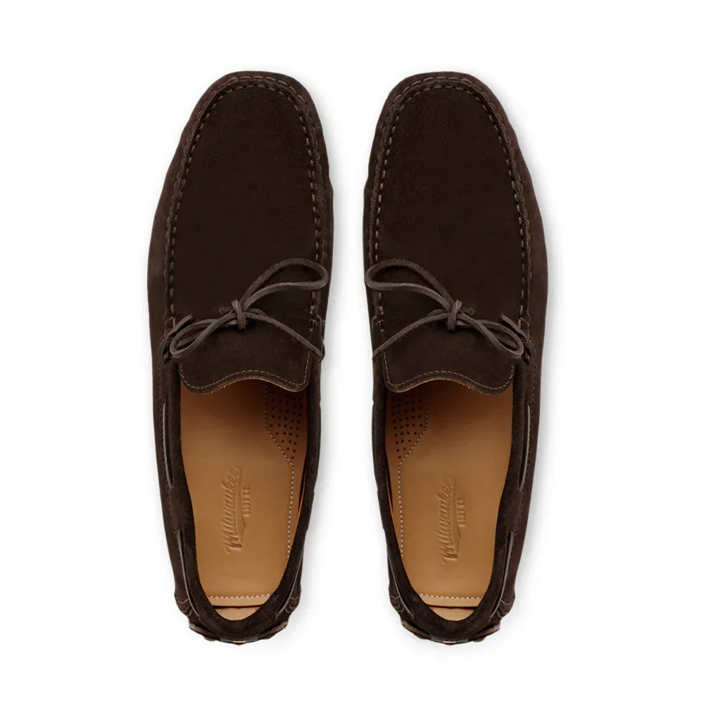 Pair of dark brown suede moc toe loafers with leather insoles and bow laces, top view