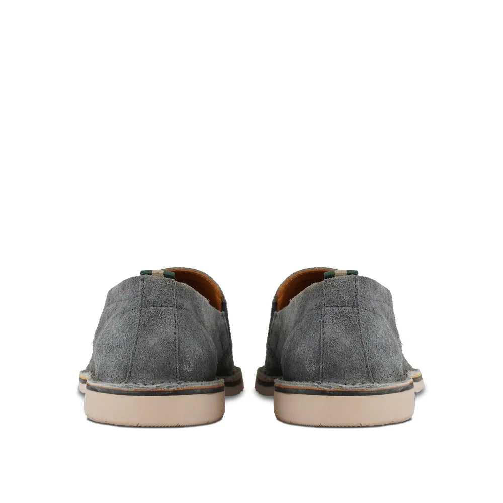 Back view of gray suede casual slip-on shoes with cream rubber soles on white background