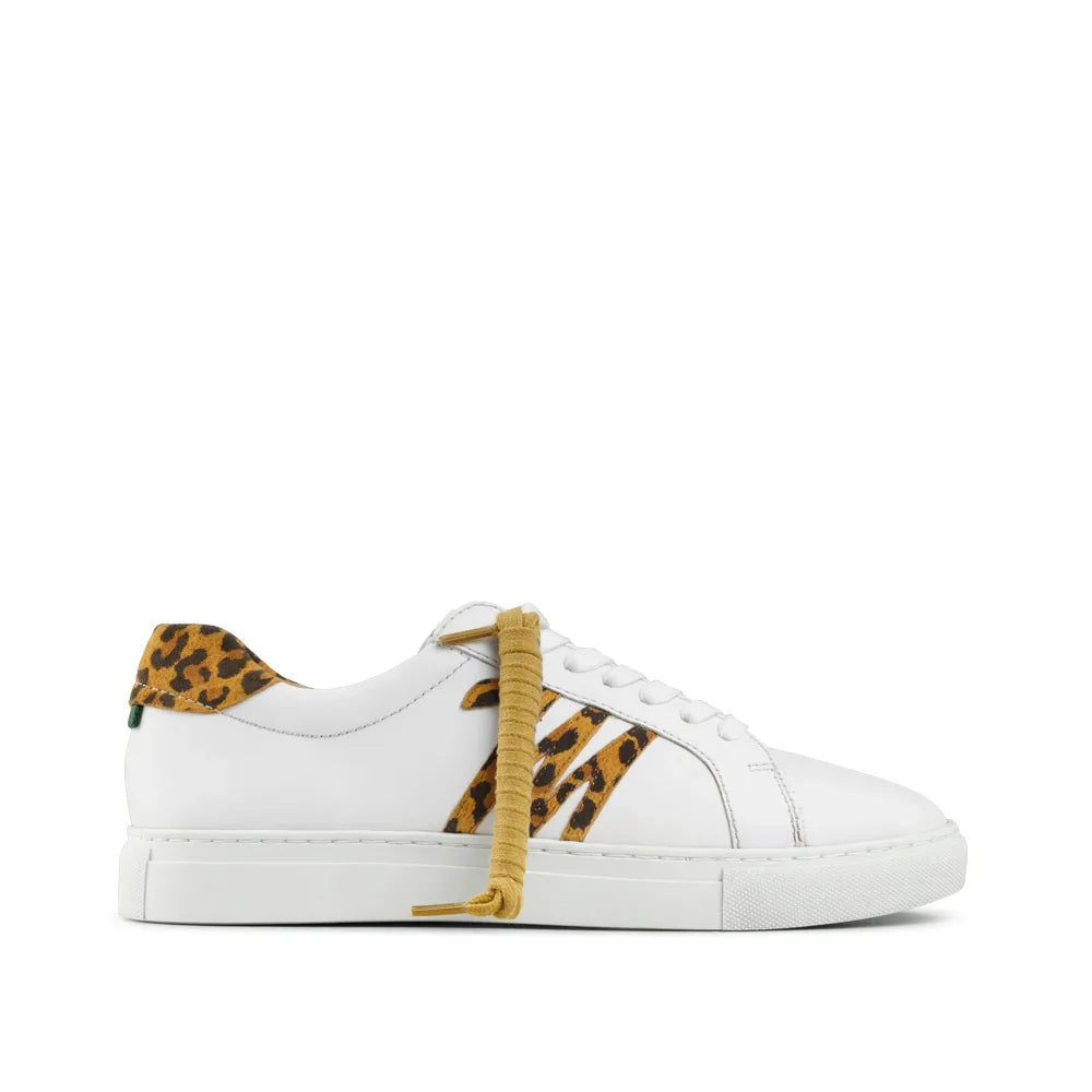 White low-top sneaker with leopard print accents and gold laces, side view on white background