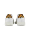 White leather sneakers with leopard print heel accent and green pull tab, rear view