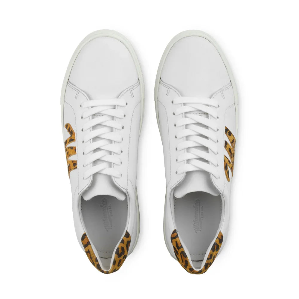 White leather sneakers with leopard print accents and laces, viewed from above on white background.
