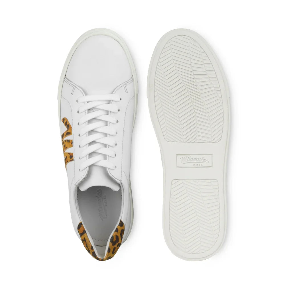 White leather sneaker with leopard print detail, flat lay showing top and sole.