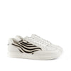 White sneakers with zebra stripe side panels and white laces on a plain background